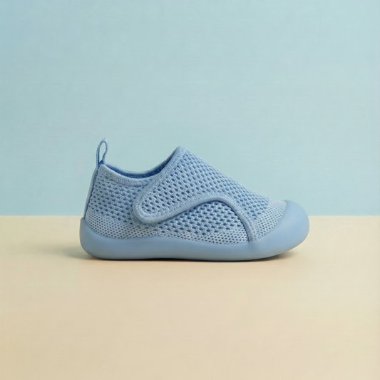 Blue children's shoe on a beige surface with a light blue background